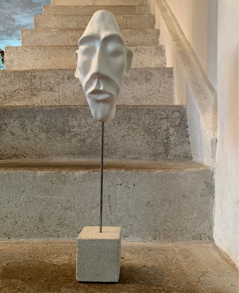 clay face sculpture on  concrete plinth
